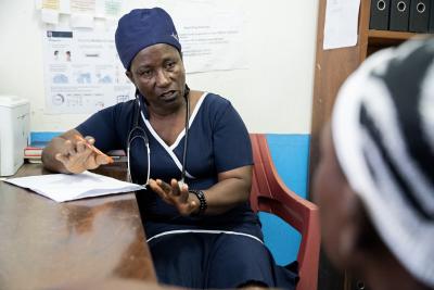 Martina Wesseh, Officer in Charge of Edith Wallace Health Center, in consultation with a patient in her office.