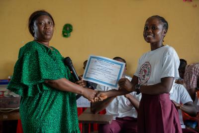 Annie Slewion, Principal of the Cape Palmas Senior High School in Maryland County, certificates Mercy T. Hinneh, captain of the Cape Palmas Senior High School team at the end of the quizzing competition. Photo by Ansumana O. Sesay / PIH