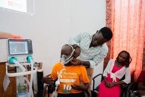 Roosevelt O. Yancy, nurse anesthetic from J.J Dossen Hospital, practices how to use the ventilator on Jean De Dieu Kaumba while Annette Tubman, CCN fellow, looks on.