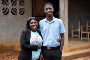 Smiling Elizabeth Sackor hugs her son, Daniel Sackor