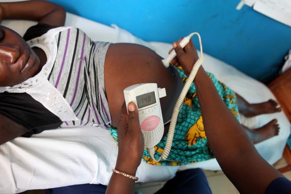 a nurse examines a pregnant woman to check her baby's vital signs