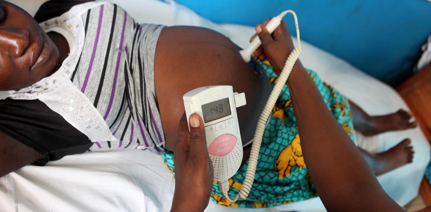 a nurse examines a pregnant woman to check her baby's vital signs