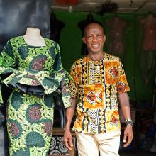 Bobby Togar stands in front of his tailor shop in Monrovia