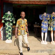 A TB survivor stands in front of his shop