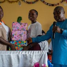 Elizabeth Wreh Sackor, PIH's Liberia’s reproductive health officer (ARSH) and Cyrus K. Wea, statistician at the Ministry of Education Maryland County office, hand over first place gift prize to Mercy T. Hinneh of Cape Palmas Senior High School at the end of the quizzing competition. Photo by Ansumana O. Sesay / PIH 