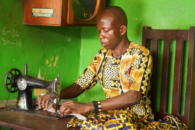 Bobby Togar works on his sewing machine in his tailoring shop in Monrovia on January 14, 2025.